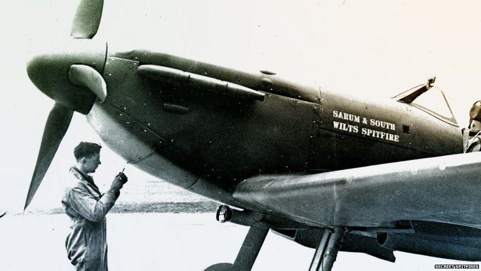 A man stands next to a Spitfire in WW2