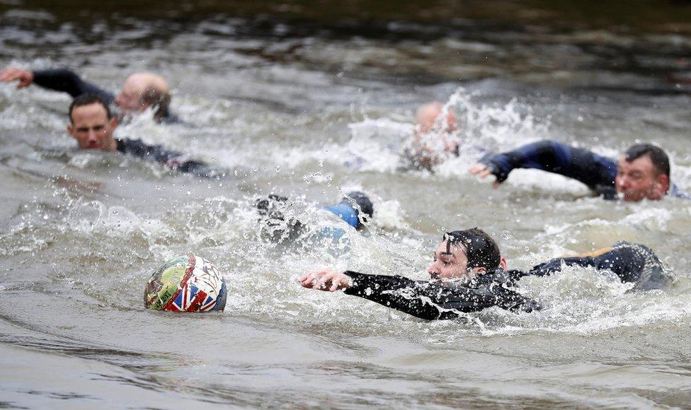 Players compete for the ball in the river during the annual Shrovetide football match in Ashbourne, 28 February 2017