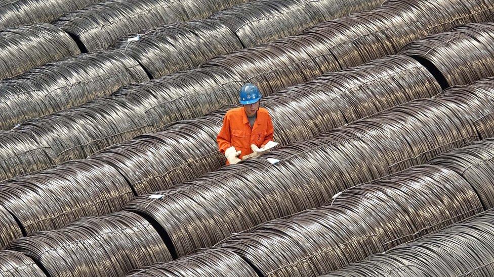 A worker checks steel wires at a warehouse in Dalian, Liaoning province, China