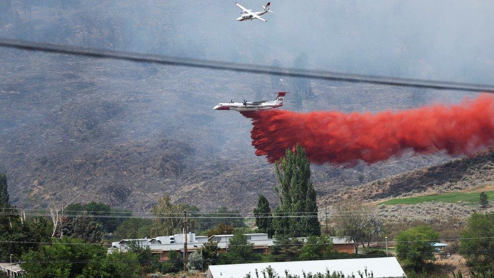 An air tanker drops fire retardant on an Eagle Bluff wildfire after it crossed the Canada-US border