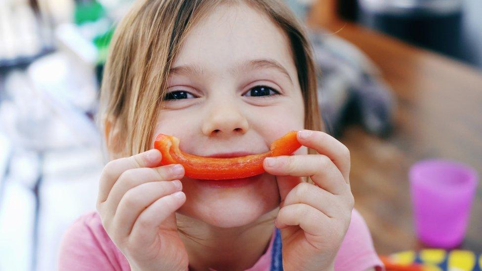 Girl eating a pepper