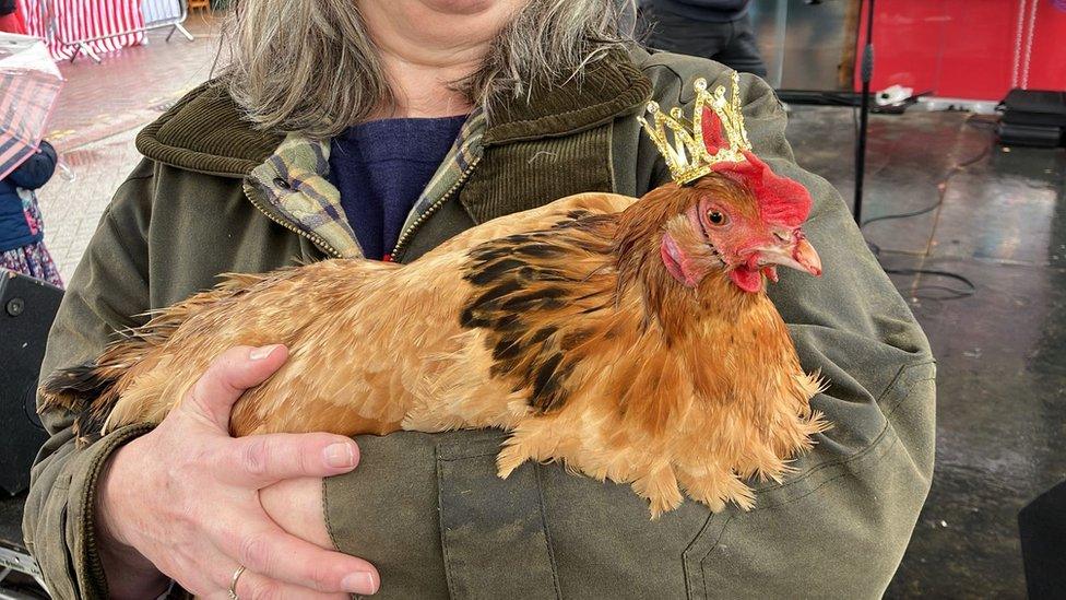 A woman holding a chicken