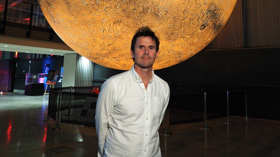 Artist in the foreground with the Mars installation behind