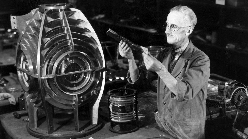 A worker assembles prisms to form the lighthouse lens