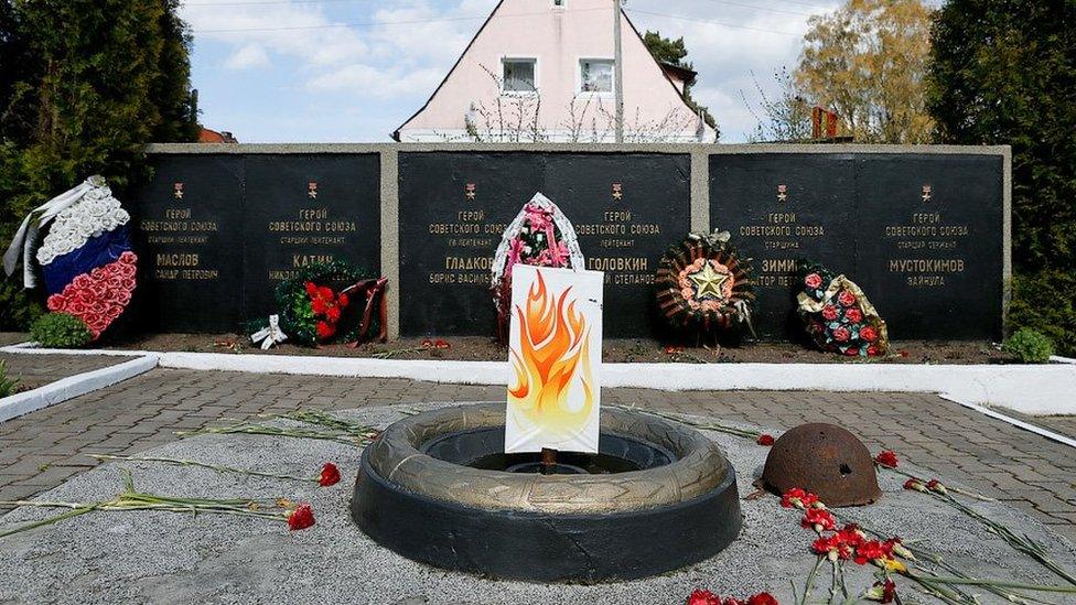 Picture of the piece of cardboard with flames painted on it, stuck on top of the monument