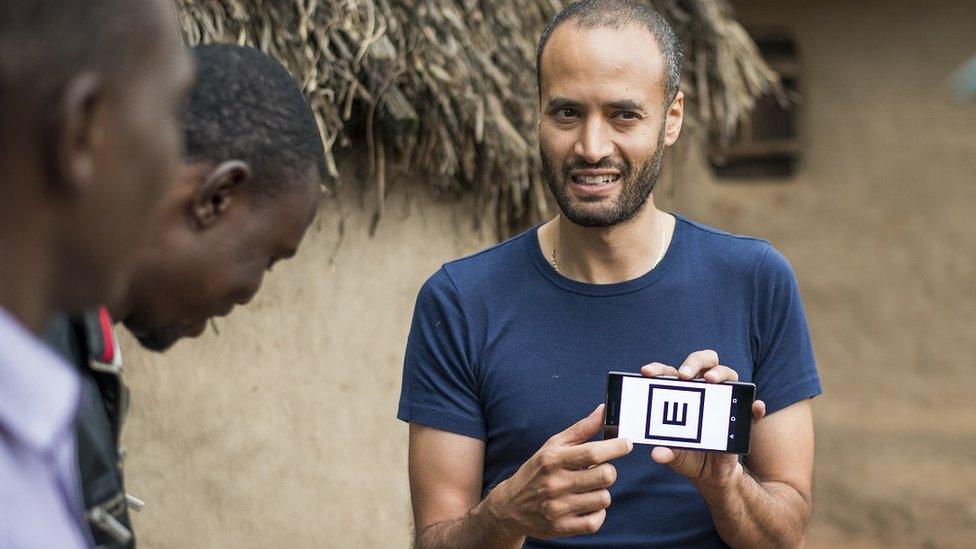 Dr Andrew Bastawrous demonstrates the Peek Acuity app to villagers in Kenya