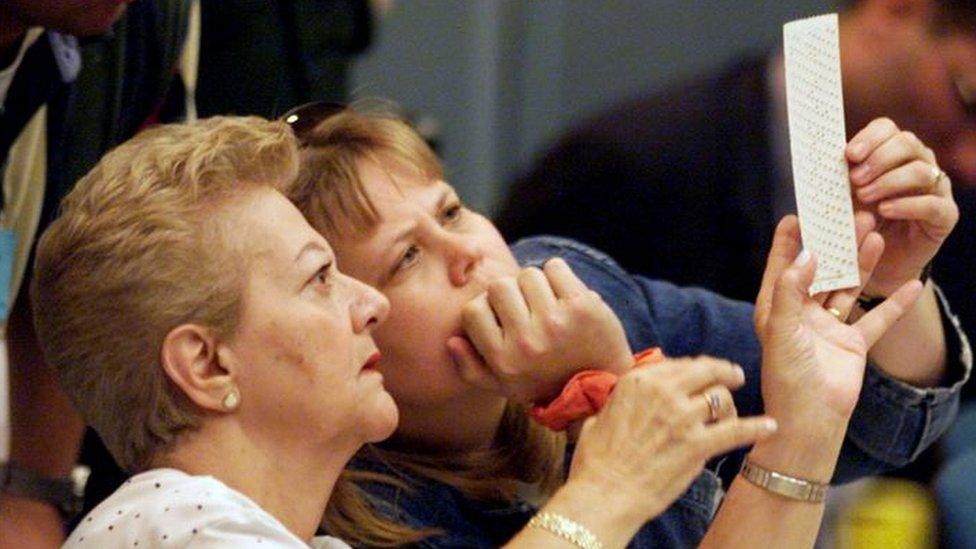 Election workers look over a ballot in Florida during the 2000 presidential election.