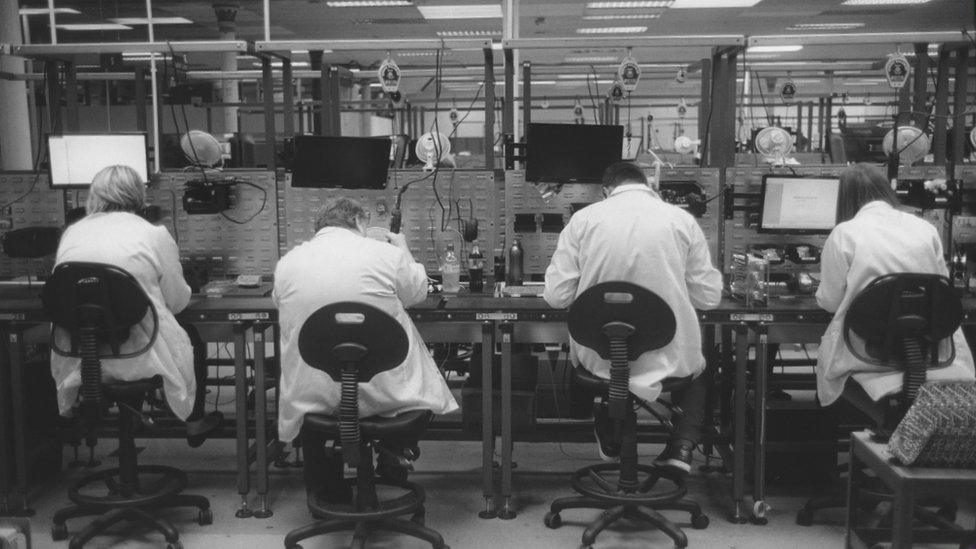 People sitting at a row of desks with computers