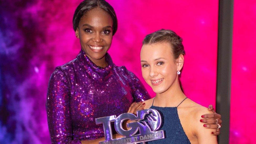 ellie and oti holding the greatest dancer trophy