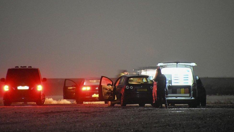 Police vehicles at the site where the body was discovered