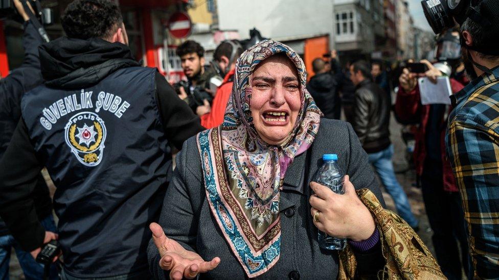 A woman cries as Turkish anti-riot police officers disperse supporters in front of the headquarters of the Turkish daily newspaper Zaman in Istanbul on March 5, 2016, after Turkish authorities seized the headquarters in a midnight raid.