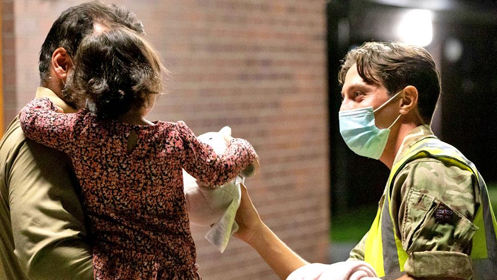 A RAF Brize Norton personnel hands out food, drinks, toys, and blankets during Operation Pitting on 26 August