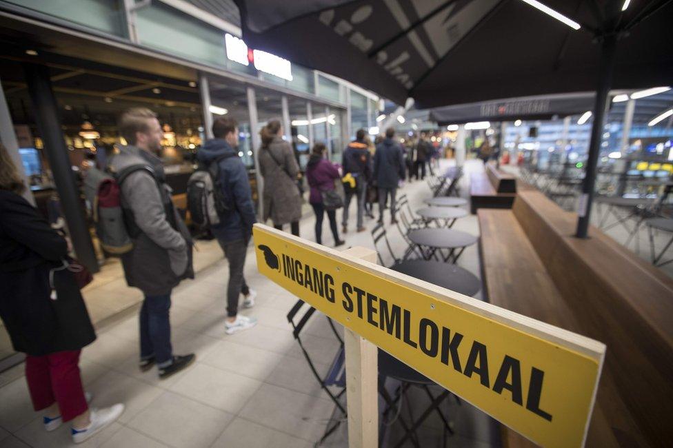 Commuters line up at a voting booth to vote in the Dutch general election at Central Station in Utrecht, 15 March