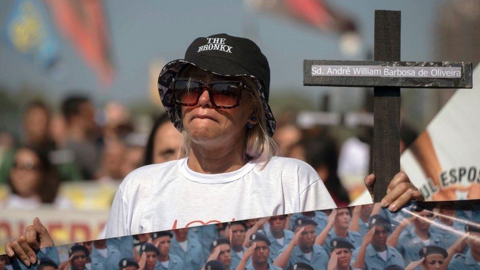 Relatives of police officers hold crosses as they protest about the death of 91 members of the security forces since the beginning of 2017 at Copacabana beach, in Rio de Janeiro, Brazil, on July 23, 2017