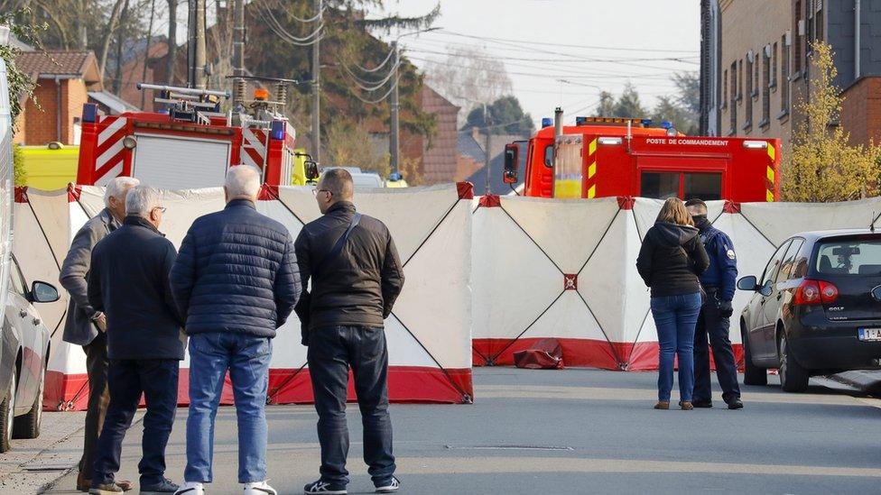 People look at the cordoned off scene in Strepy Bracquegnies, Belgium