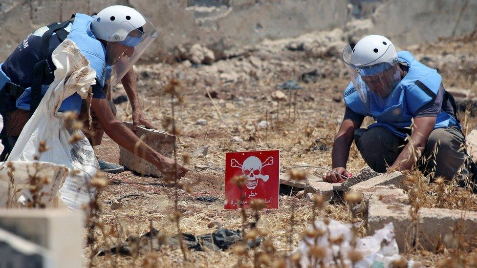 Civil defence members prepare to safely detonate cluster bombs in a rebel-held area in Deraa, Syria (26 July 2017)