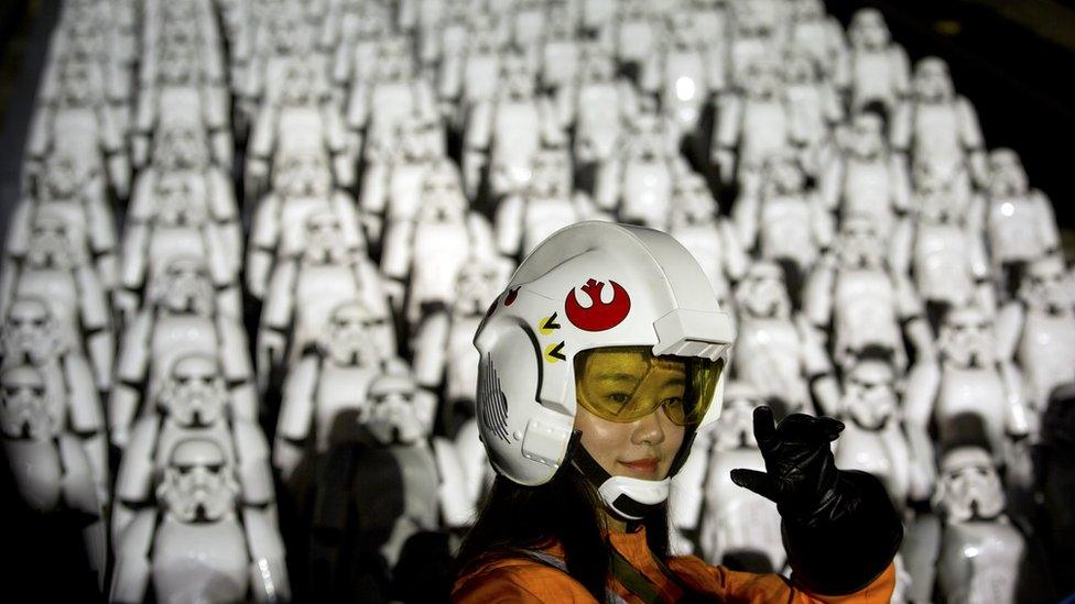 A Chinese fan poses for a photo in front of storm troopers at the Great Wall of China