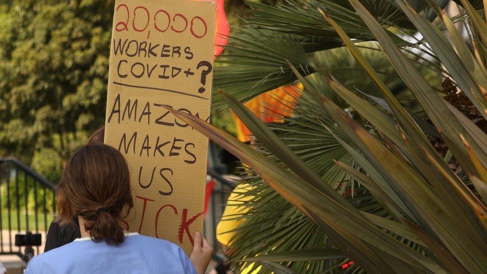 Woman with placard marching to Jeff Bezos' house