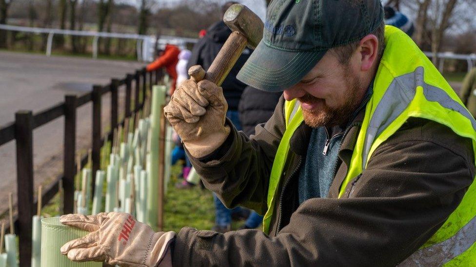 A man planting trees as part of a rewilding project with Creating Nature's Corridors