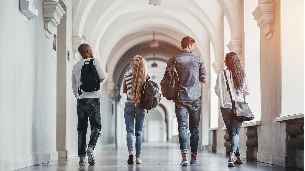 students walk along corridor