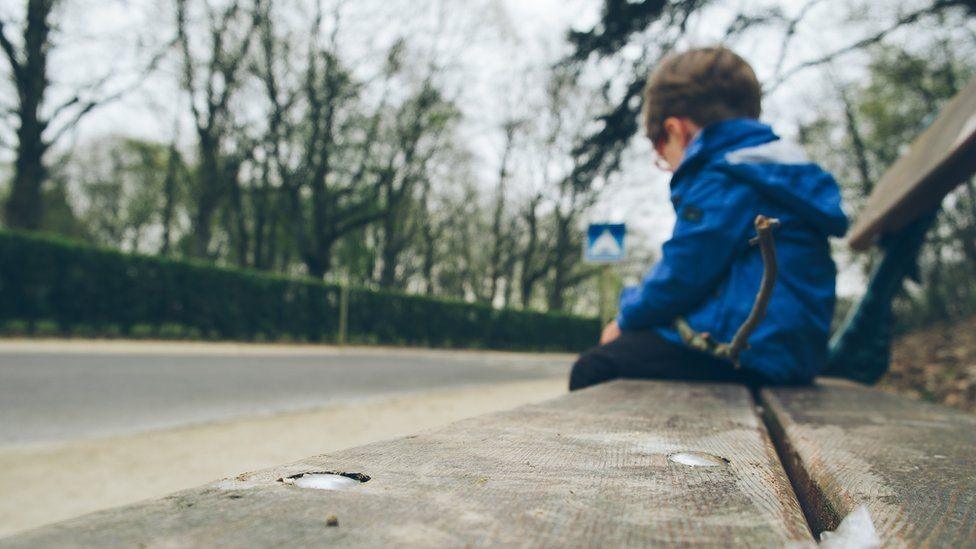 A photo of a child on a bench