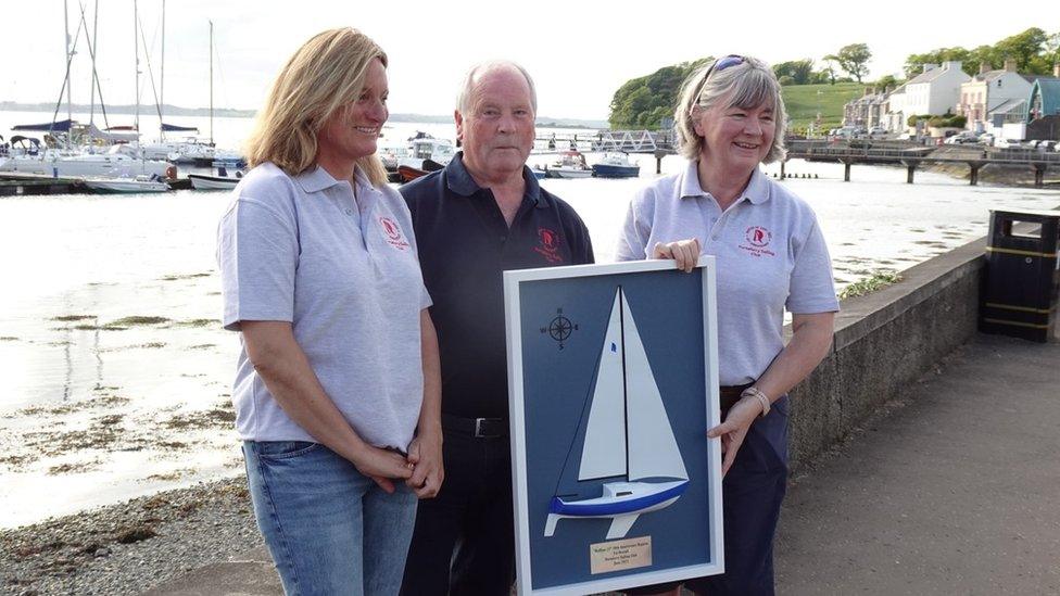 Heather Kennedy, John McAlea and Karen Brown holding the race winner's trophy