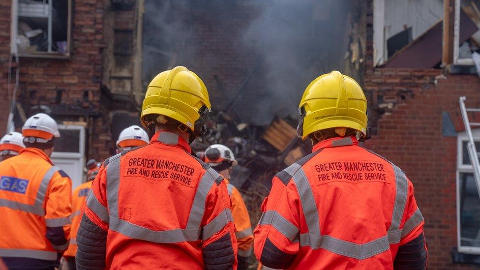 Fire crews look at the explosion at the Bury home