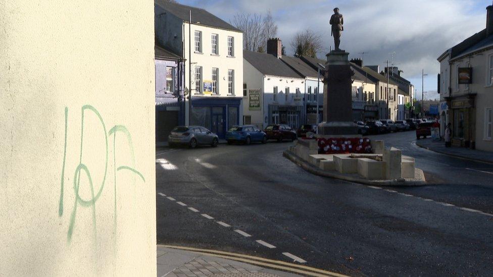 IRA painted on a wall with a war memorial in the background