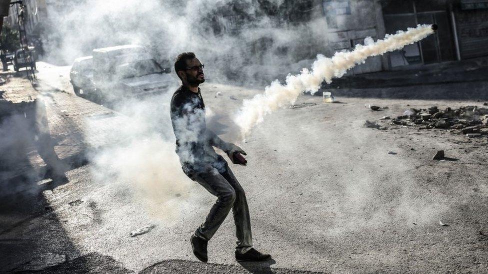 A left-wing militant clashes with Turkish police officers on 25 July