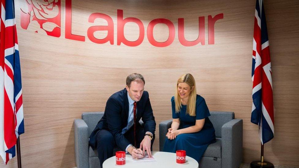 Dan Poulter signing form beneath Labour banner