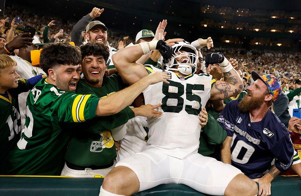 Tucker Kraft celebrates with Green Bay Packers fans after scoring an eight-yard touchdown against the Washington Commanders in the fourth quarter of their NFL match at Lambeau Field. Photo by Michael Reaves