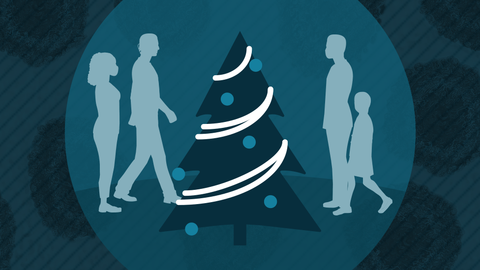 Four people around a Christmas tree