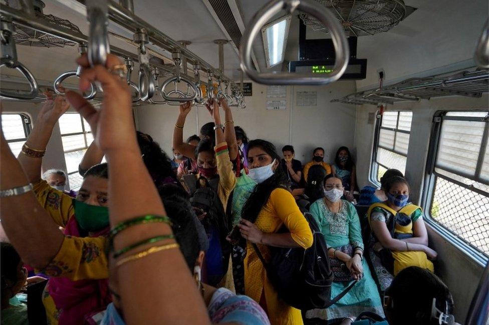 Women covering their faces with protective masks commute in a suburban train after authorities resumed the train services for all commuters after it was shut down to prevent the spread of the coronavirus disease (COVID-19) in Mumbai, India, February 1, 2021