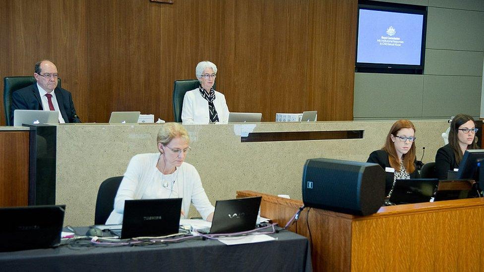 Inquiry officials seated at a public hearing in 2015