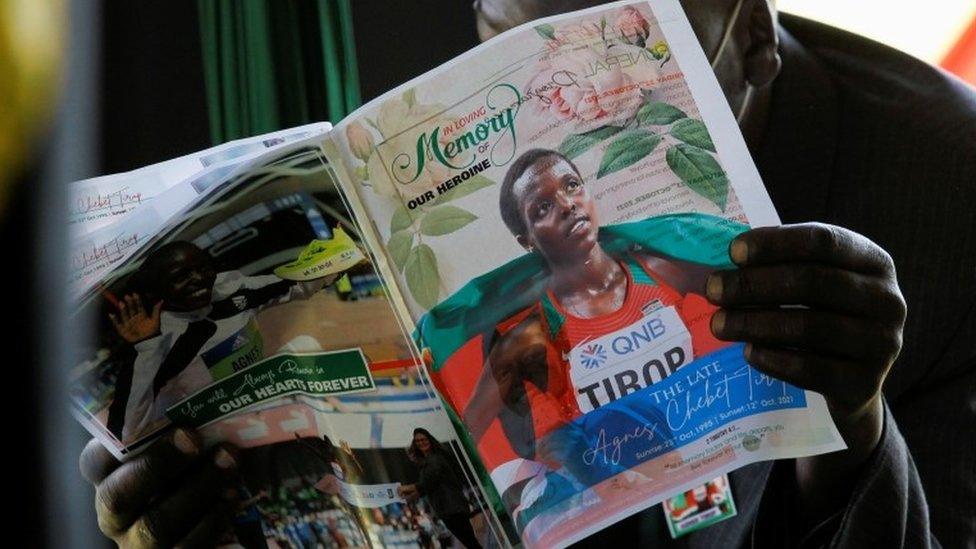 A mourner reads the eulogy program during the funeral service of long-distance runner Agnes Tirop