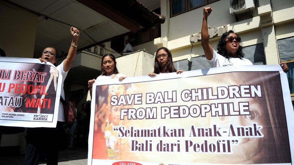 Activists display banners against paedophilia in front of a holding cell where Australian Robert Andrew Fiddes Ellis was waiting before attending his trial at a court in Denpasar, on the Indonesian resort island of Bali on July 14, 2016.