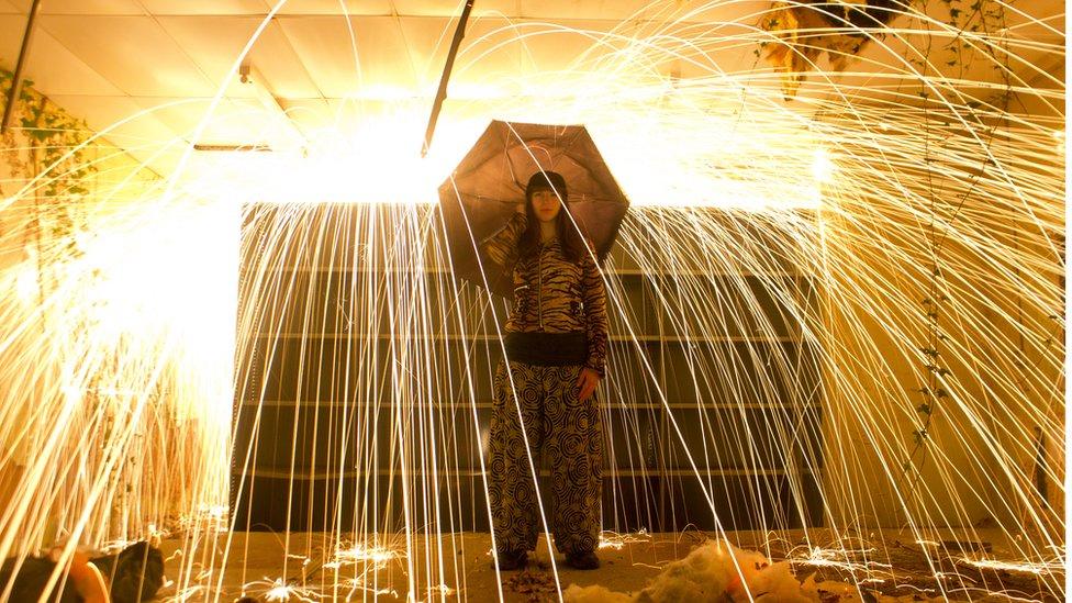 Photograph of a girl holding an umbrella under a light shower