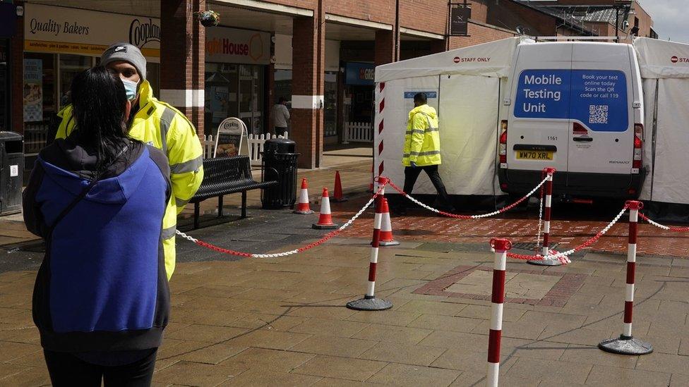 People waiting to visit a mobile testing unit