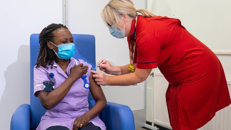 A nurse receives a Covid-19 booster jab