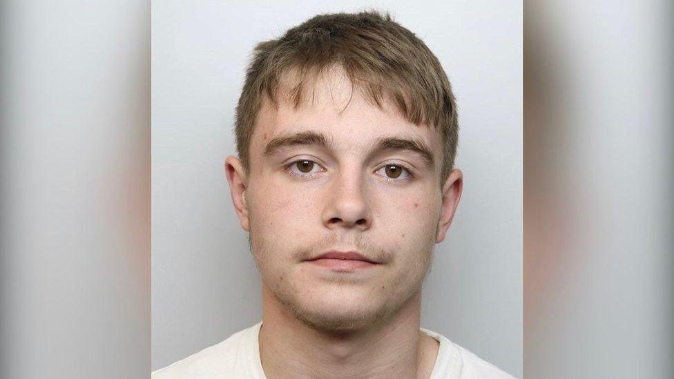 Young man with short hair in police mugshot