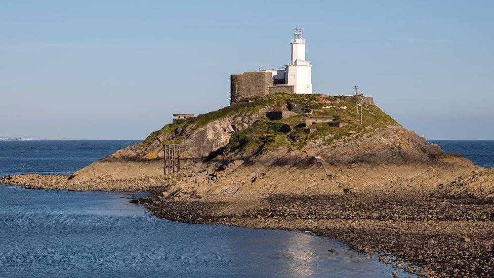 Lighthouse at low tide Mumbles Head, Gower peninsula, near Swansea, South Wales, UK.