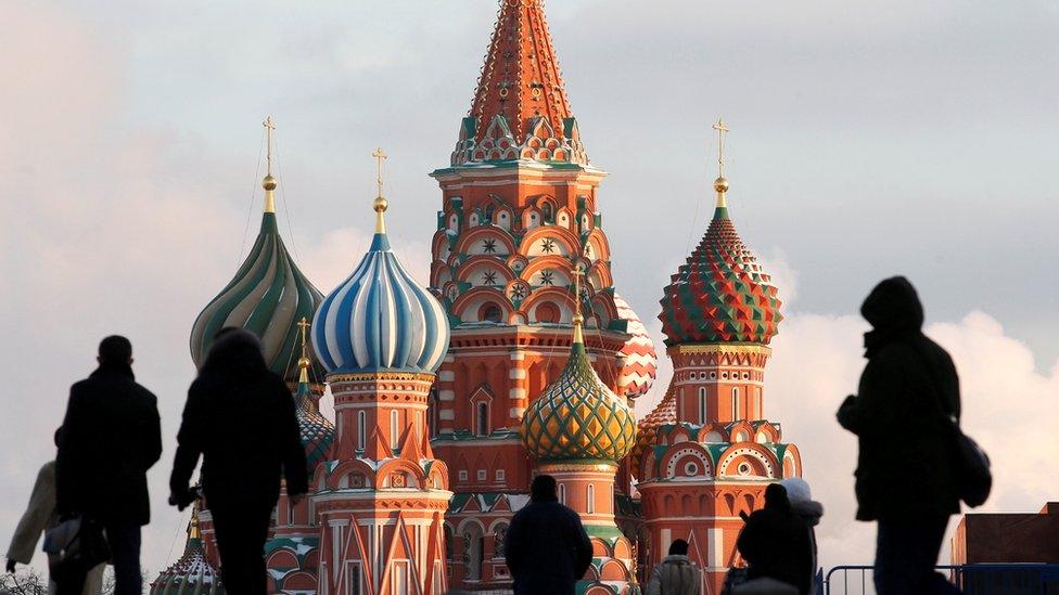 People silhouetted against St. Basils Cathedral, in Red Square, with Moscow, Feb 2016