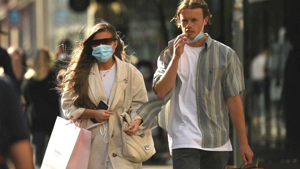 A couple wearing face coverings in Manchester City Centre