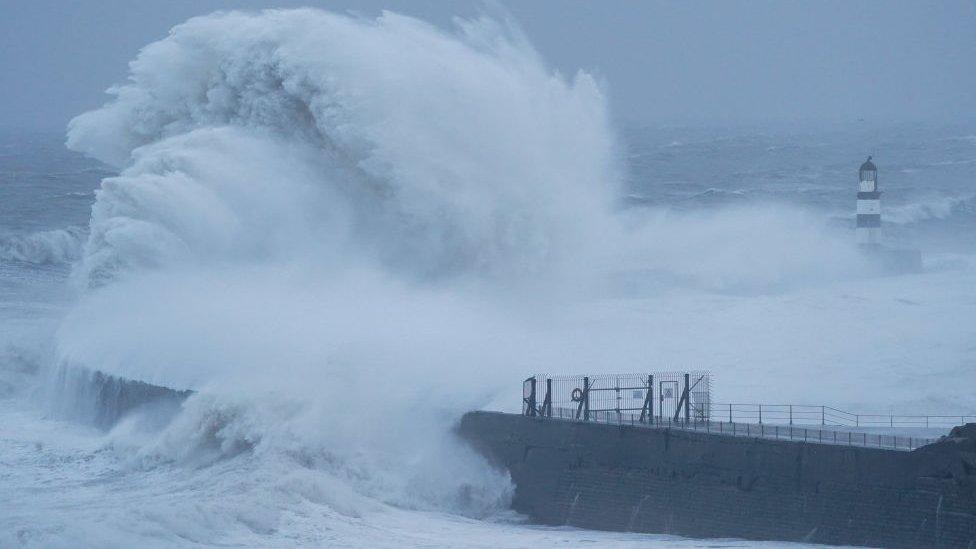 Huge waves break over the sea wall and lighthouse at Seaham Harbour in County Durham