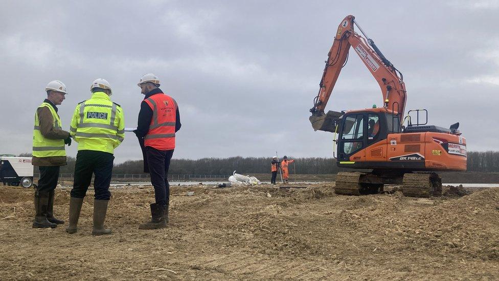 Three people stood on a building site