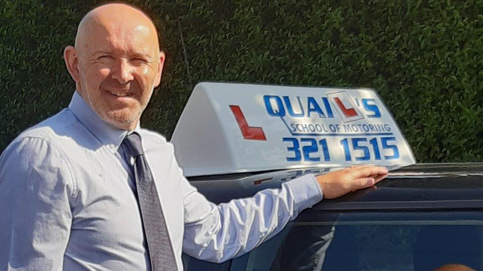 Graham Quail next to one of Quail's School of Motoring's vehicles