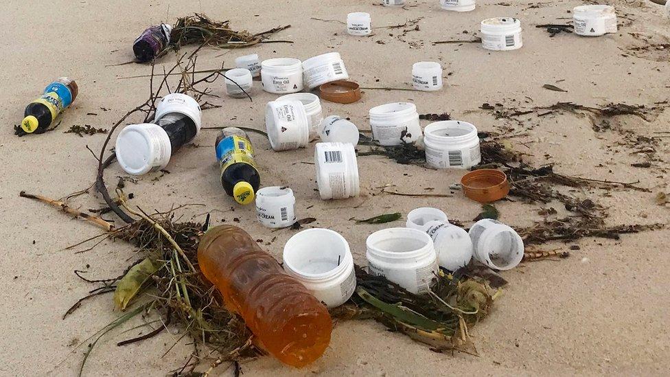 Plastic jars and drink bottles are among the debris to have washed up on beach near Port Stephens in New South Wales