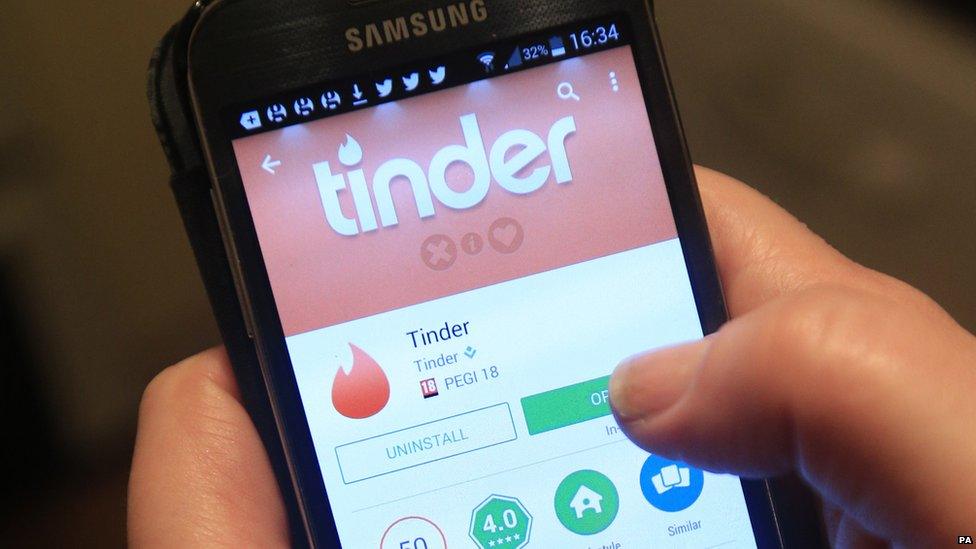 Tinder app being downloaded on a phone