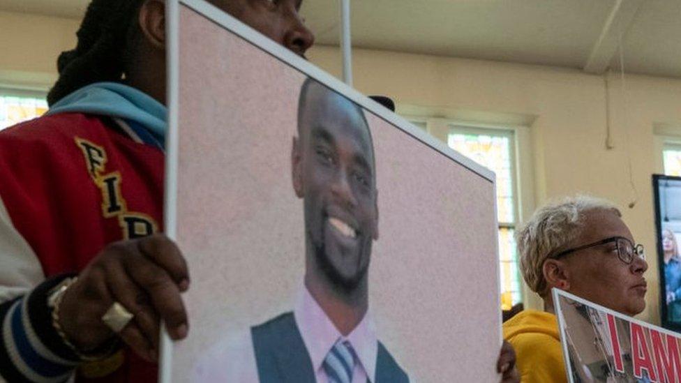 Activists hold signs showing Tyre Nichols during a press conference on Monday