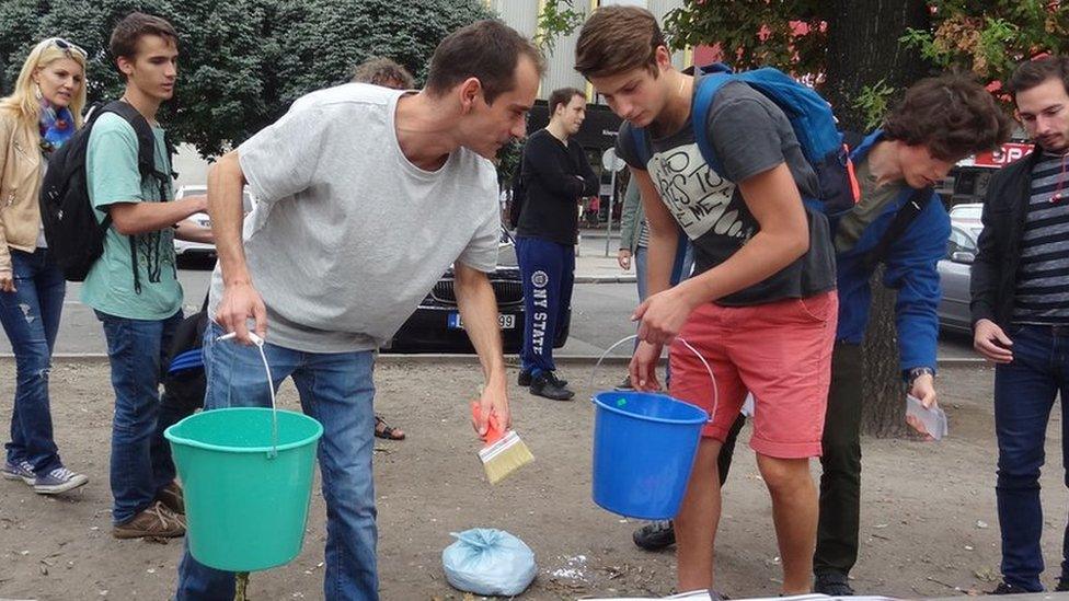 Gergely Kovacs and fellow activists putting up posters